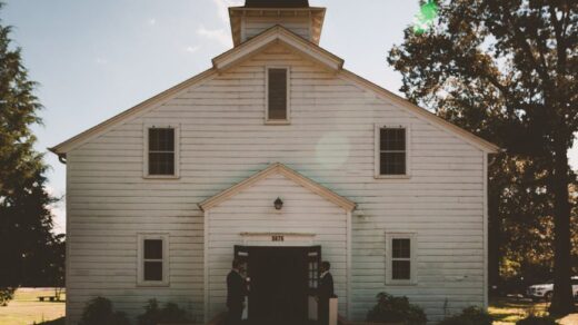 two person standing near white church