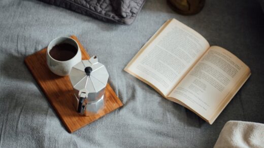 coffee with book on cozy bed