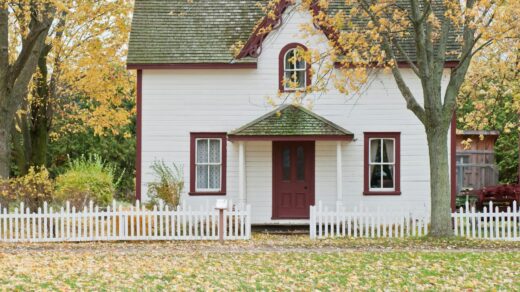white and red wooden house with fence