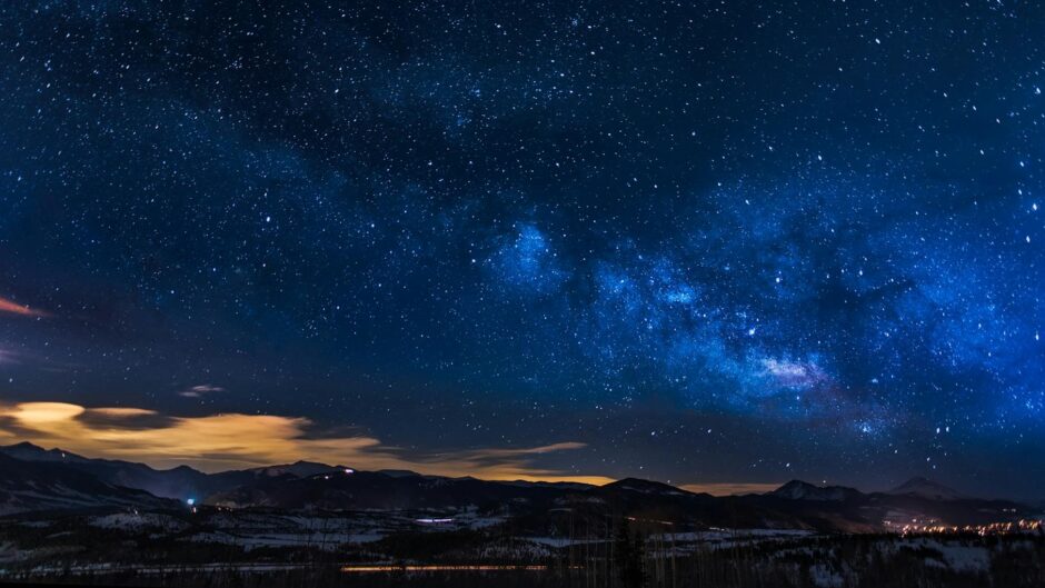 black mountains under the stars at nighttime