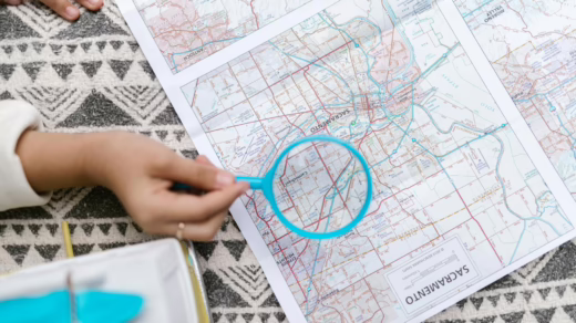person holding blue magnifying glass over a map